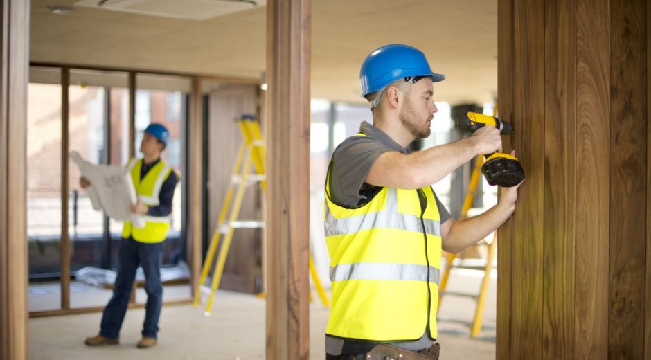 site foreman runs over blueprints while joiner cracks on